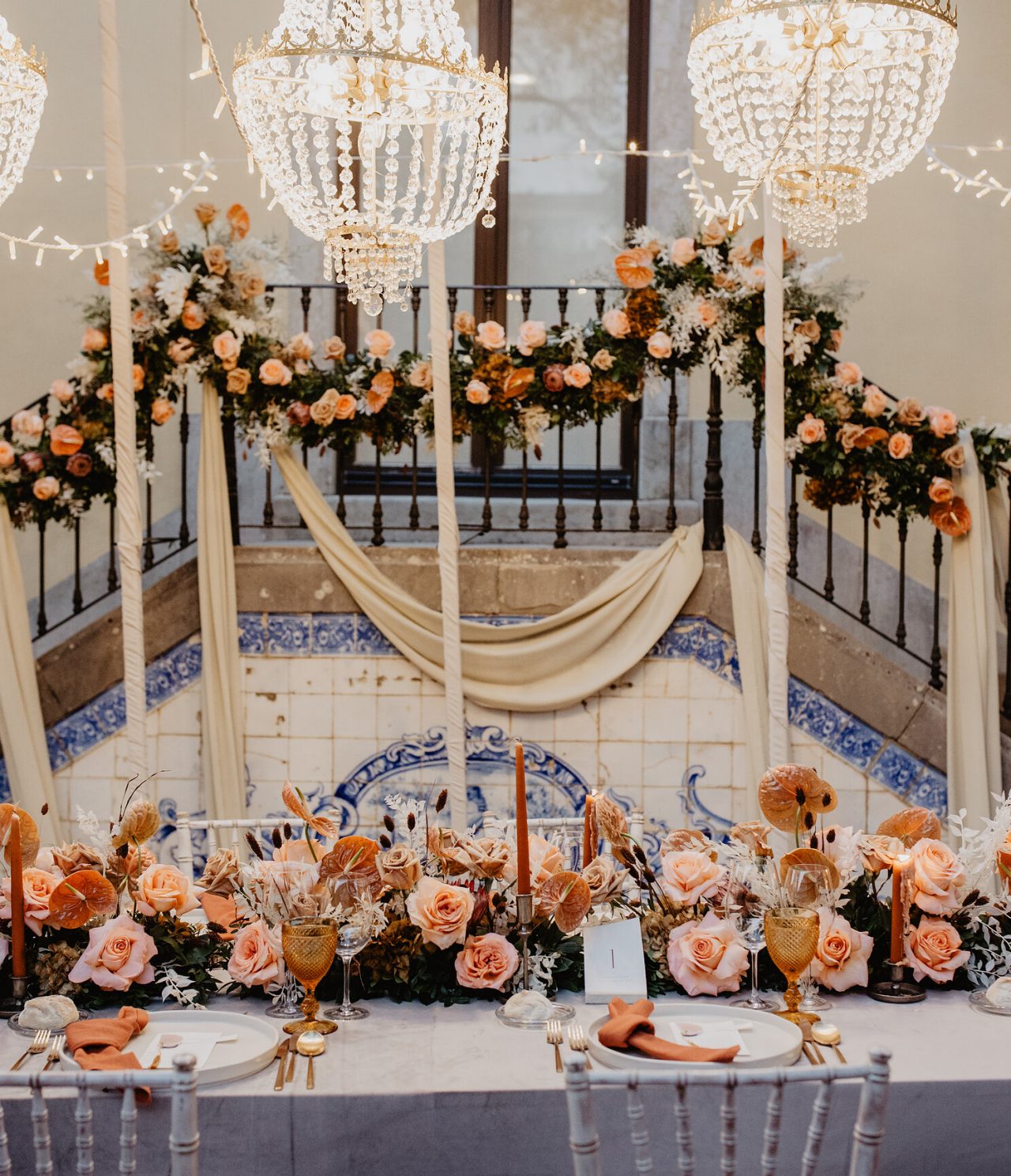 Espacio decorado para una boda en las Pousadas de Portugal, con una mesa larga adornada con arreglos florales de rosas