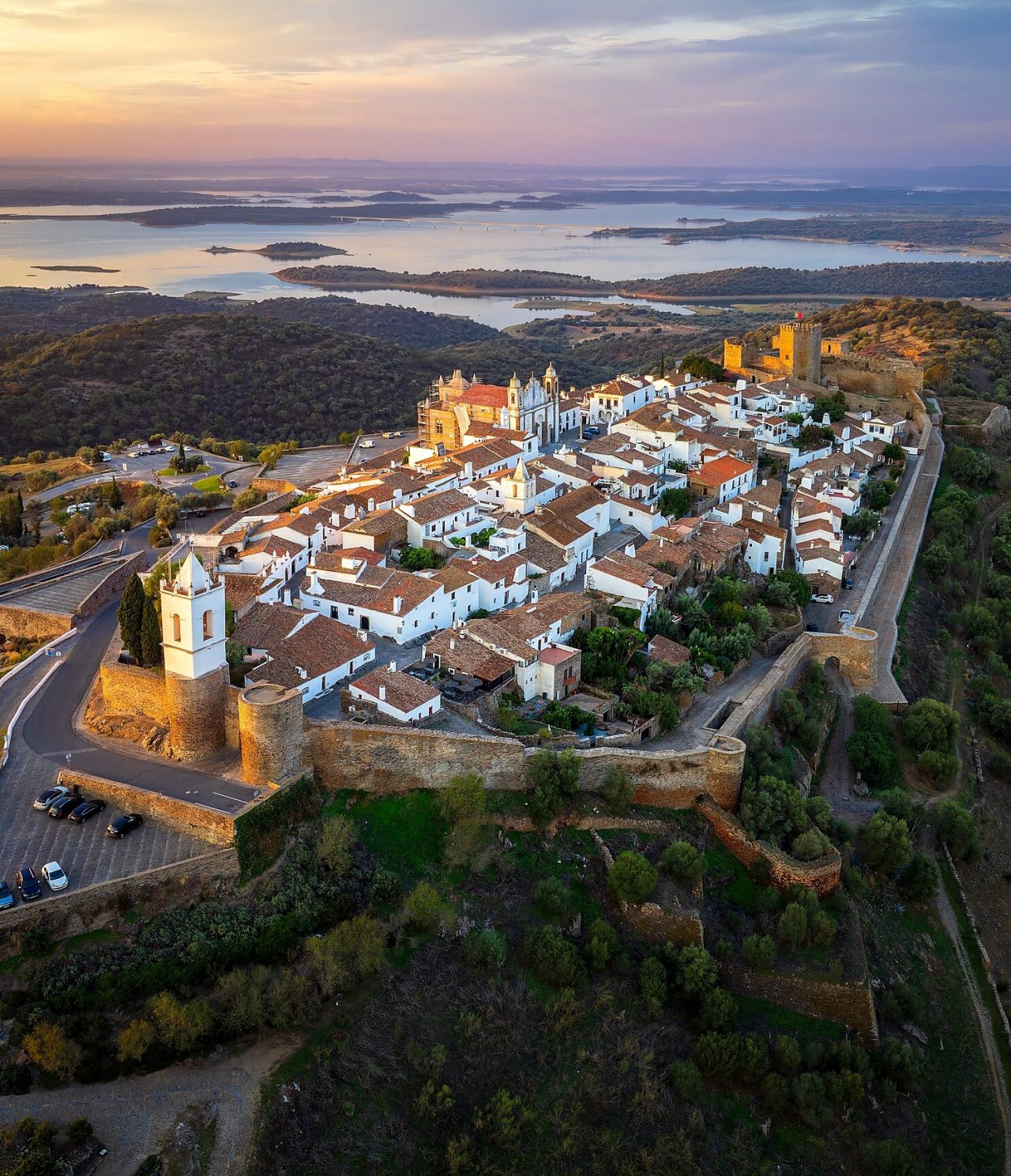 Vista aérea para a colina Monsaraz, no Alentejo ao pôr do sol, com um castelo, uma catedral e a vila