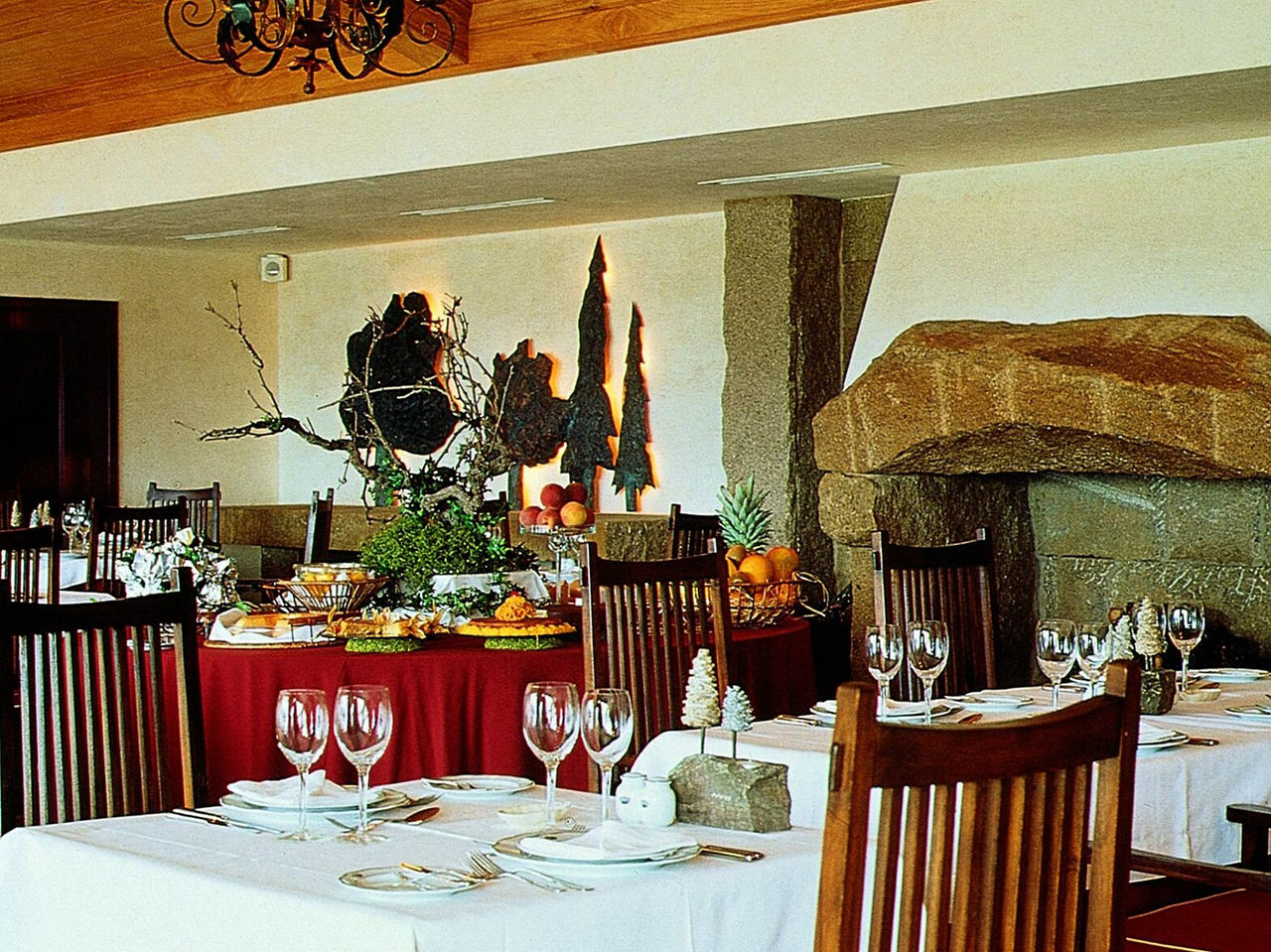 O restaurante do Hotel Histórico em Belmonte, tem mesas para refeições e um buffet atrás com doçaria e fruta