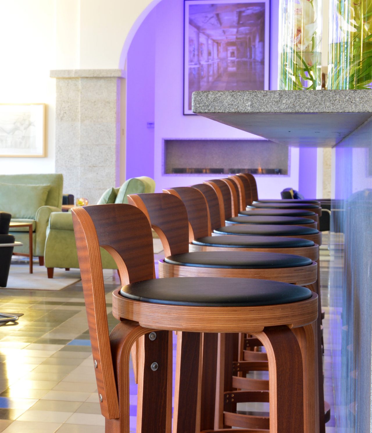 O bar Pousada Serra da Estrela, do Hotel Histórico na Serra da Estrela, tem um balcão com várias cadeiras de madeira