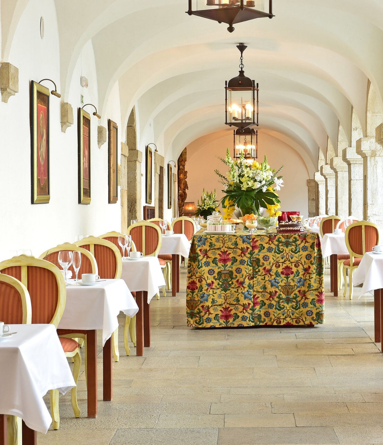 O restaurante Pousada Castelo Palmela, do Hotel com Vista para a Serra da Arrábida, tem tetos altos com arcos e várias mesas