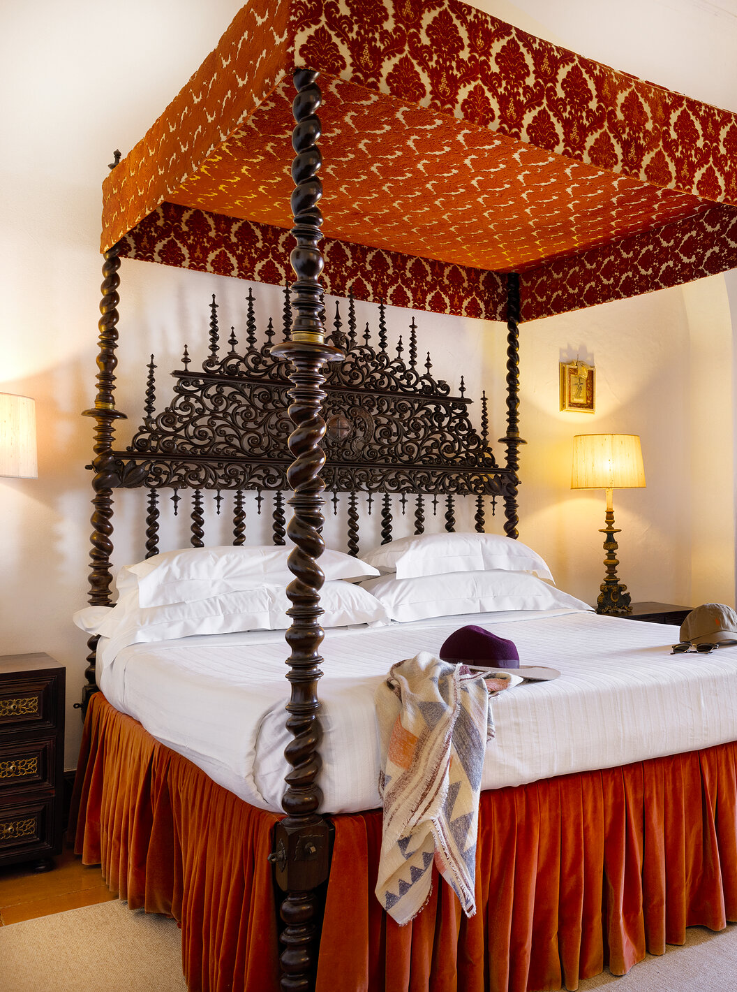 Die Junior Suite der Pousada Castelo Estremoz hat ein antikes Doppelbett mit einem Baldachin aus Stoff und dunklem Holz