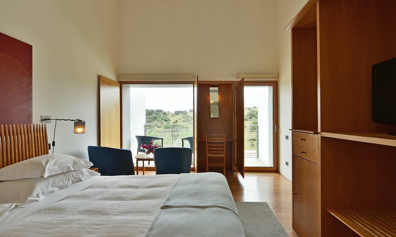 Das Superior Familienzimmer der Pousada Convento Arraiolos hat einen Balkon mit Blick auf Alentejo Täler mit zwei Stühlen