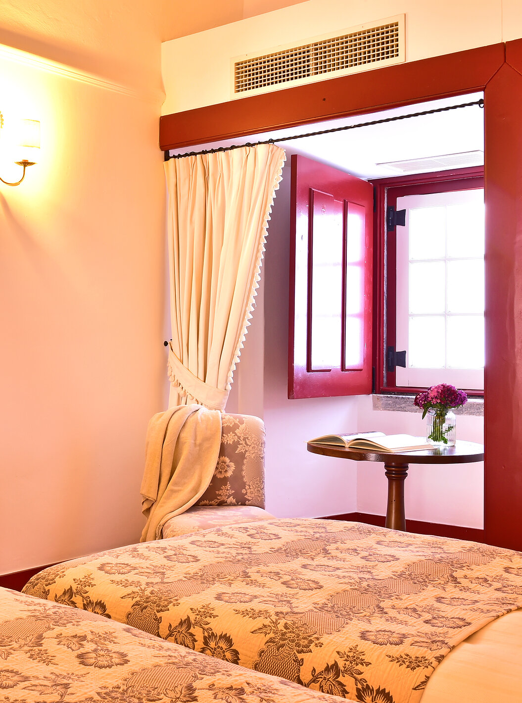 Das Superior Zimmer der Pousada Convento Beja hat einen Beistelltisch mit einem Stuhl am Fenster