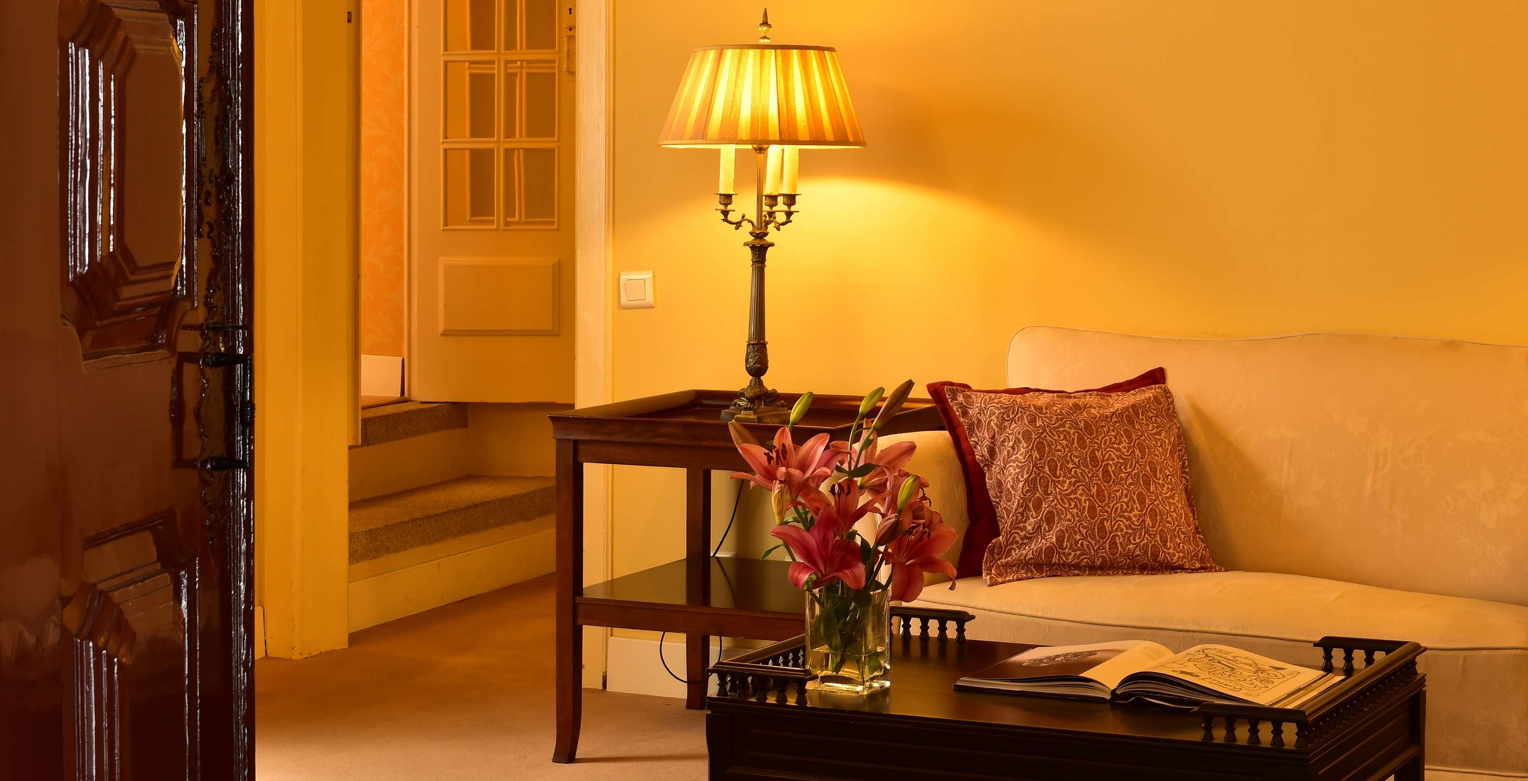 Die Suite Spezial der Pousada Convento Évora hat einen Wohnbereich mit Sofa und einem Tisch mit Blumen