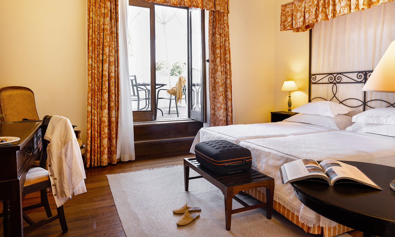 Das Klassische Zimmer der Pousada Convento Vila Viçosa hat zwei zusammenstehende Betten, eine Bank und einen Gepäckablage