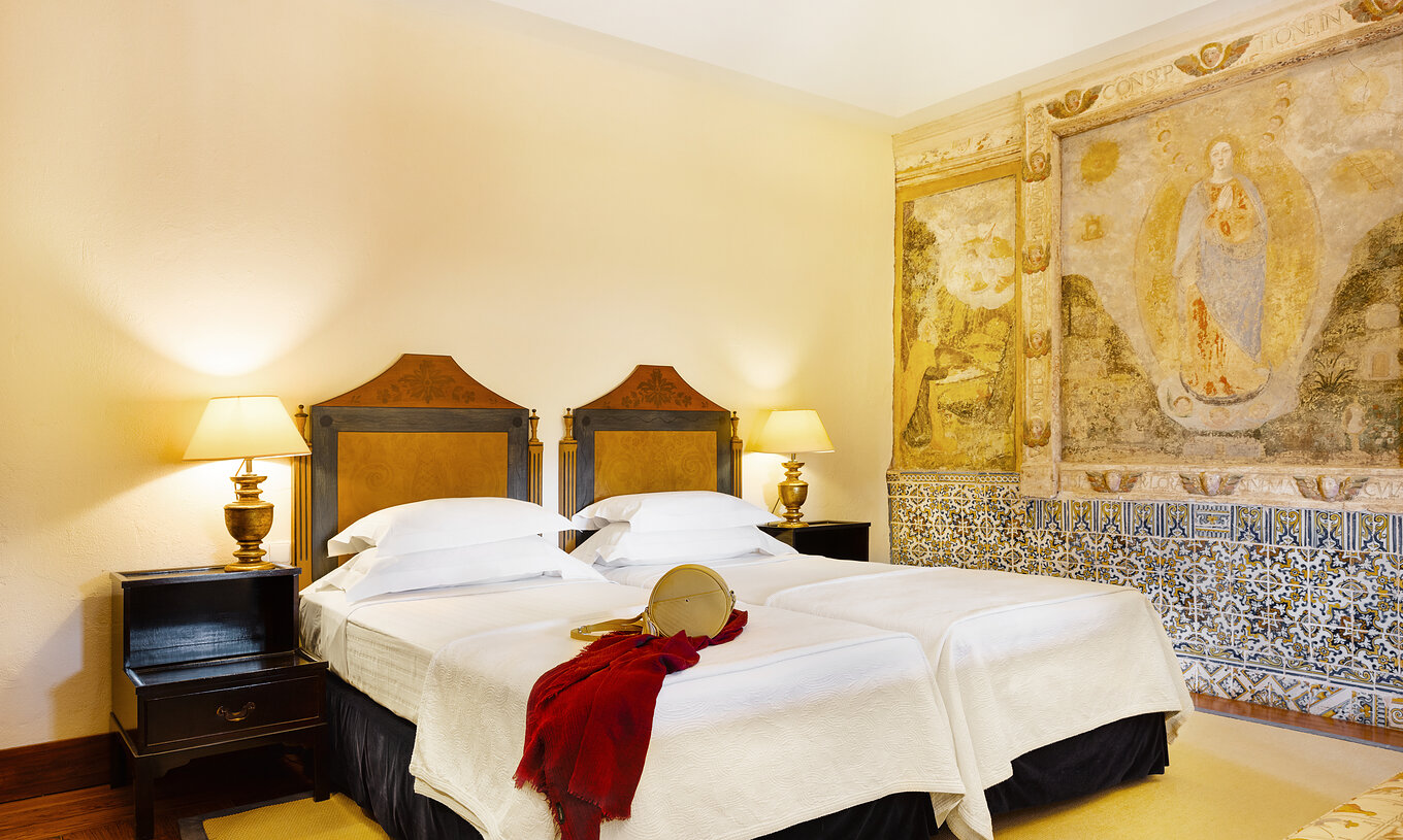 Die Suite der Pousada Convento Vila Viçosa hat Einzelbetten, Nachttisch mit Lampe und Fliesen an der Wand