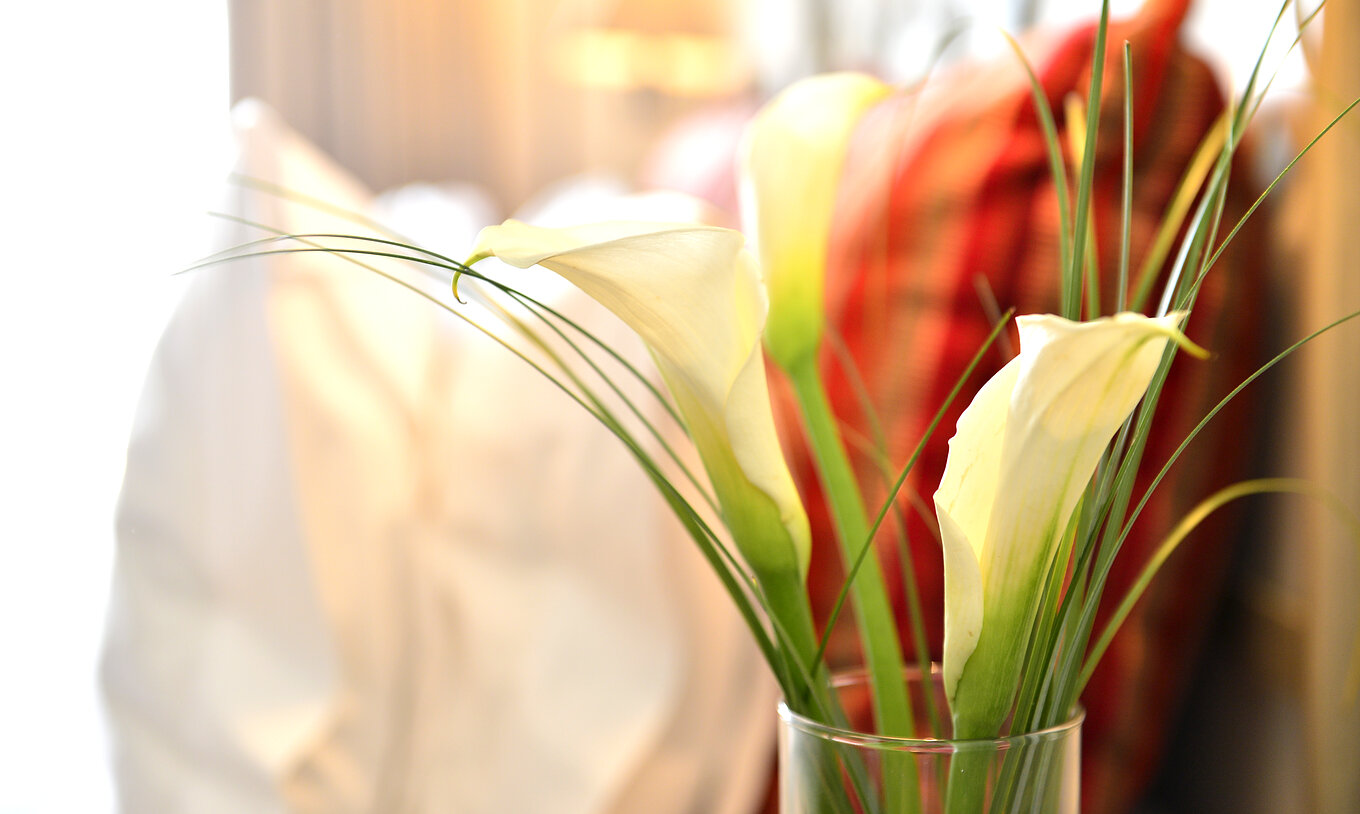 Das Doppelzimmer der Pousada Marvão hat verschiedene Dekorationselemente, wie eine Vase mit weißen Blumen