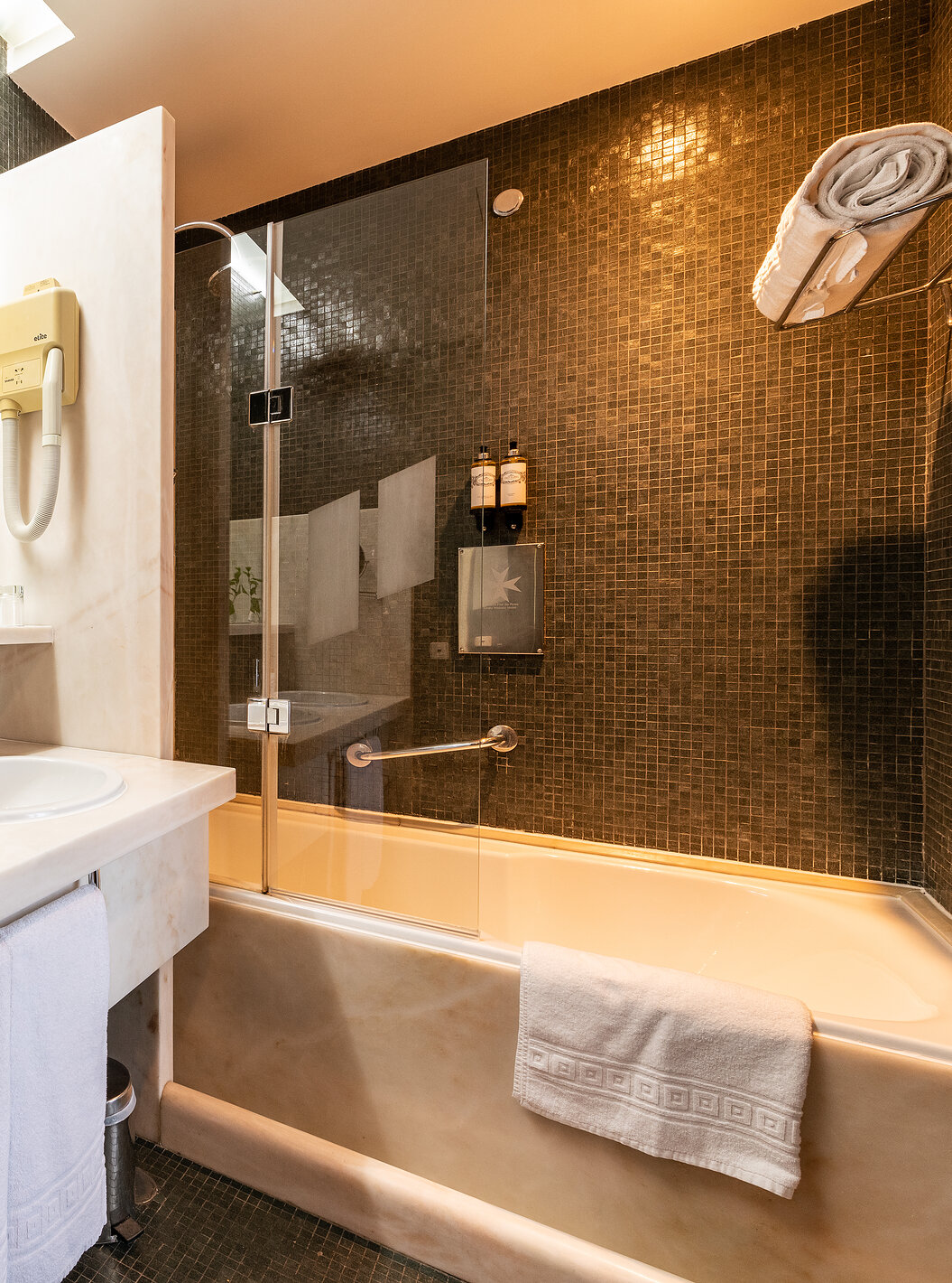 Der klassische Raum der Pousada Mosteiro Crato hat ein Badezimmer mit schwarzen Fliesen, Badewanne und zwei Waschbecken