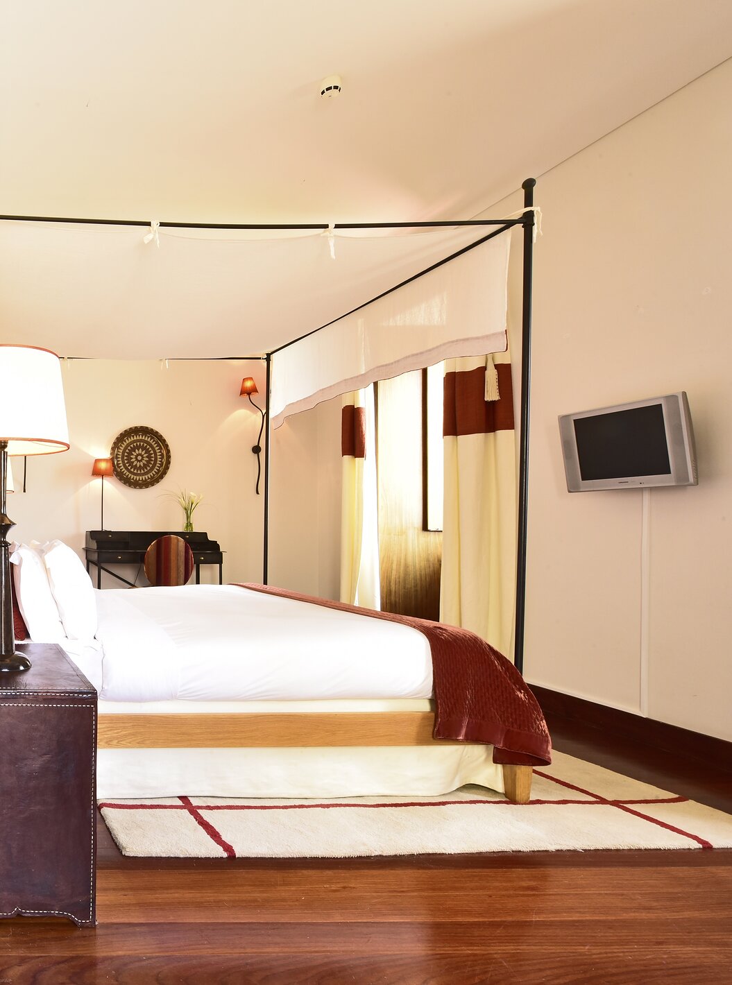 Die Spezial Suite der Pousada Convento Tavira hat eine Schiebetür, die das Schlafzimmer mit Doppelbett und Wohnzimmer trennt