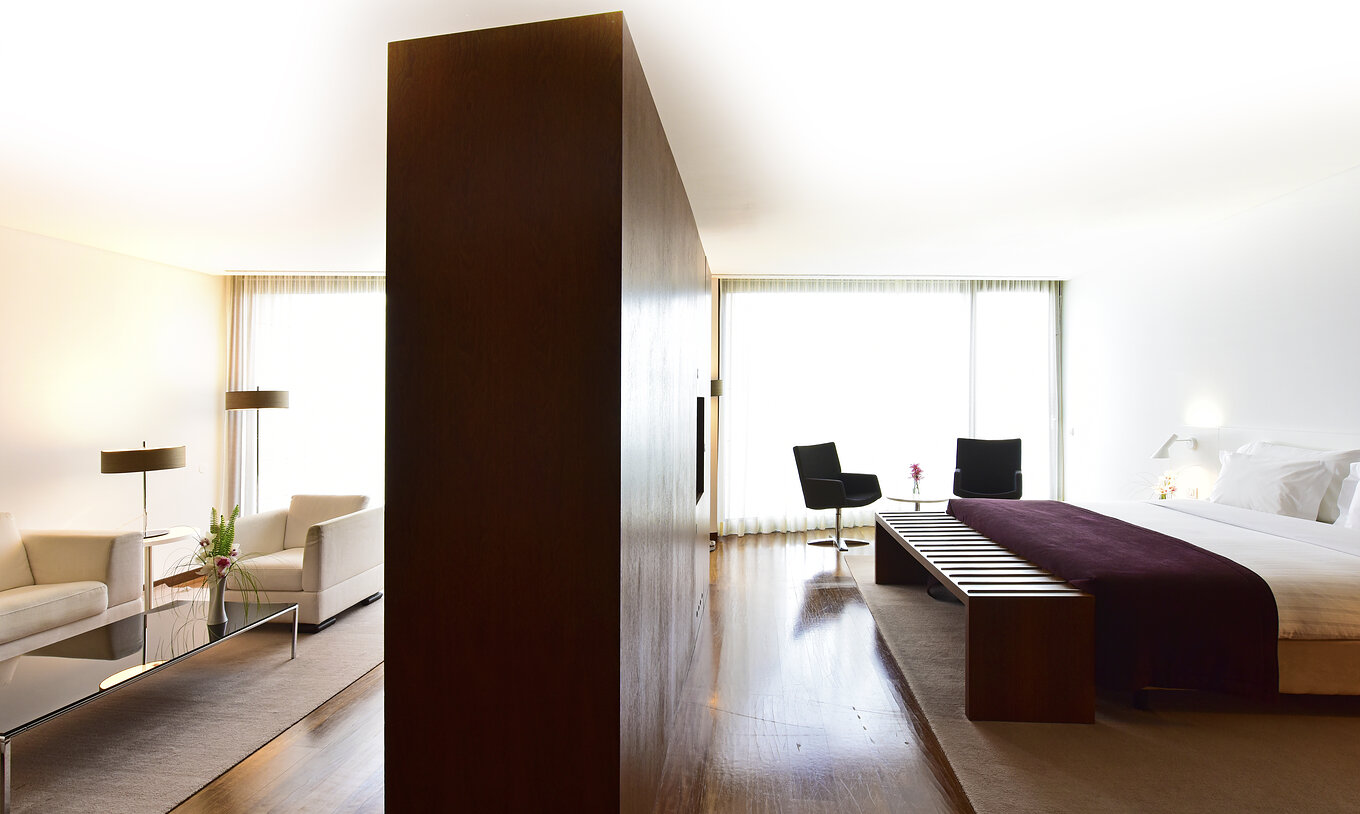 Die Standard-Suite der Pousada Palácio Estoi mit Doppelbett und Schrank, der den Raum mit dem Wohnzimmer teilt