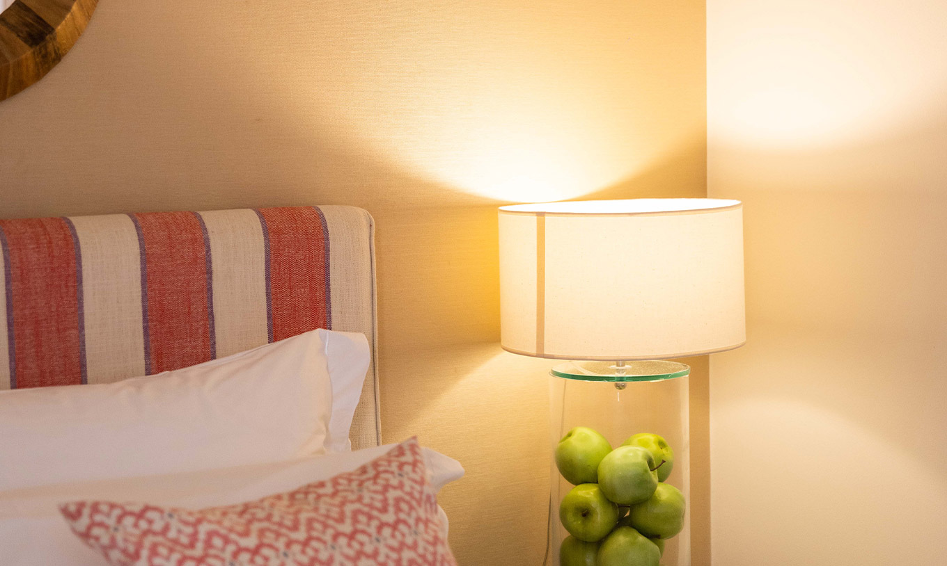 Das Classic Zimmer der Pousada Sagres hat ein buntes Kopfteil und eine Lampe mit grünen Äpfeln im Inneren