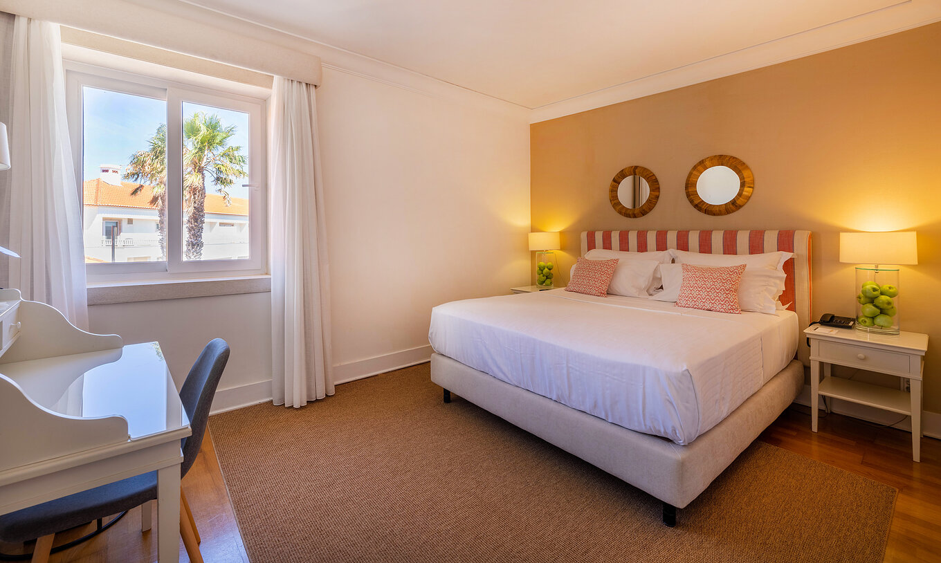 Das klassische Zimmer der Pousada Sagres hat zwei Betten mit gestreiftem Kopfteil, zwei Spiegel, Fenster und Schreibtisch