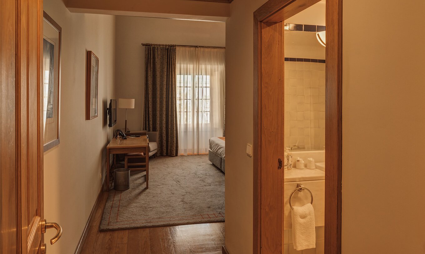 Die Suite der Pousada Ourém hat ein Bad und einen Teppich unter dem Bett und nah am Fenster