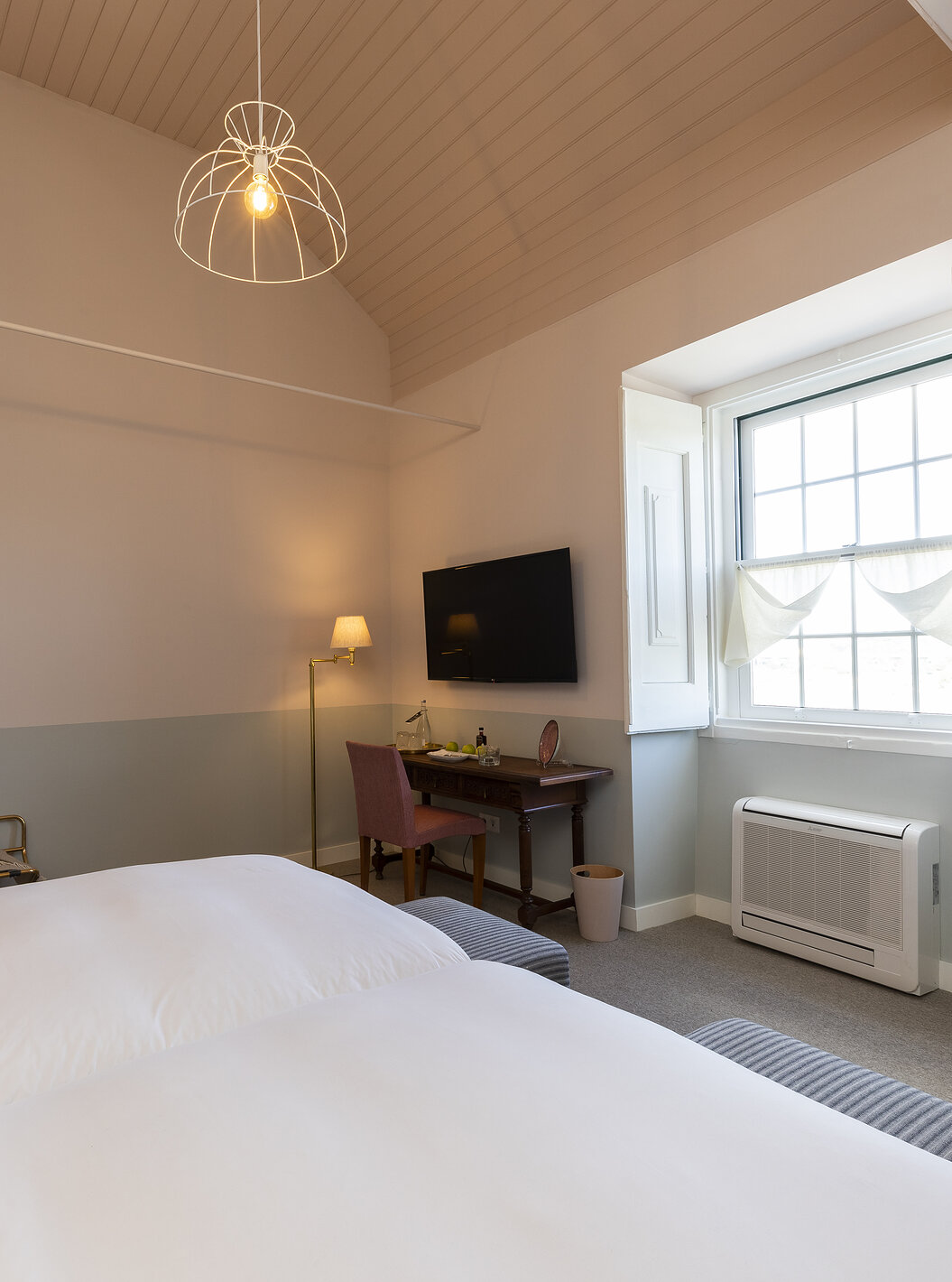 Das Superior Room der Pousada Vila Óbidos hat eine Deckenlampe und zwei Betten, ein Fenster und einen Fernseher