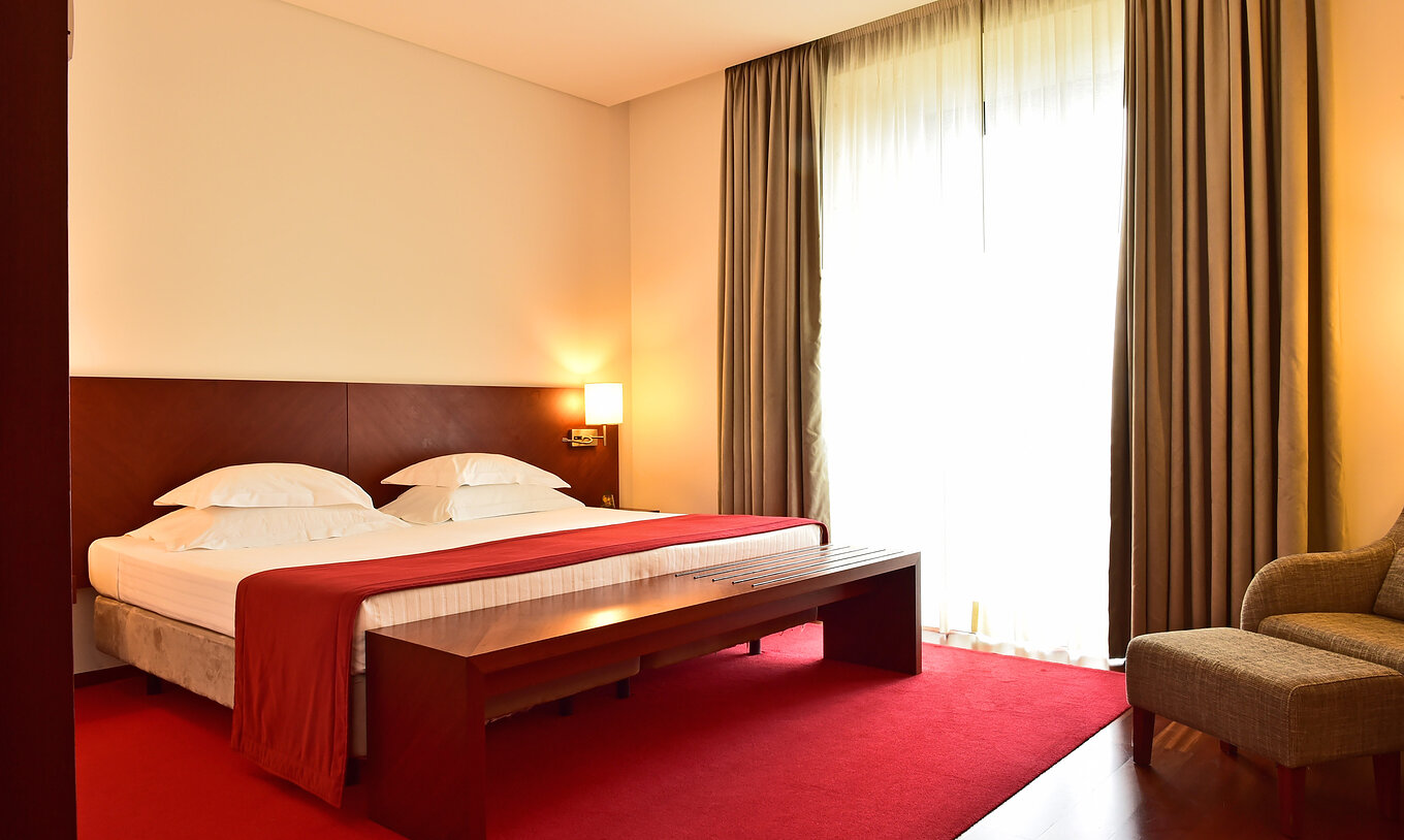 Das Large Family der Pousada Viseu hat ein Doppelbett und einen Nachttisch mit Lampe