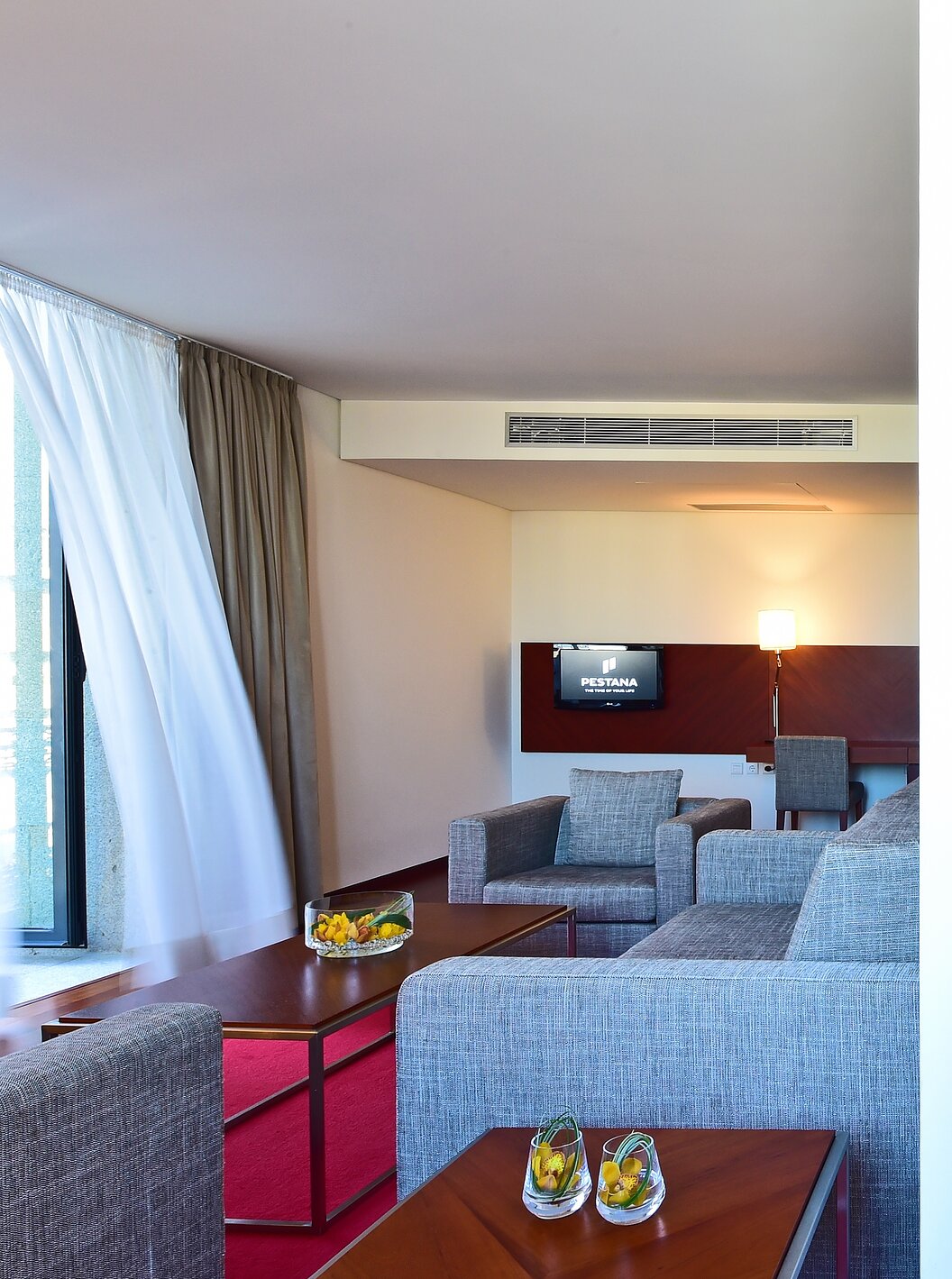 Die Mezzanine Suite der Pousada Viseu hat zwei Sessel, ein Sofa, einen Schreibtisch, Fernseher und Treppe zur Mezzanine