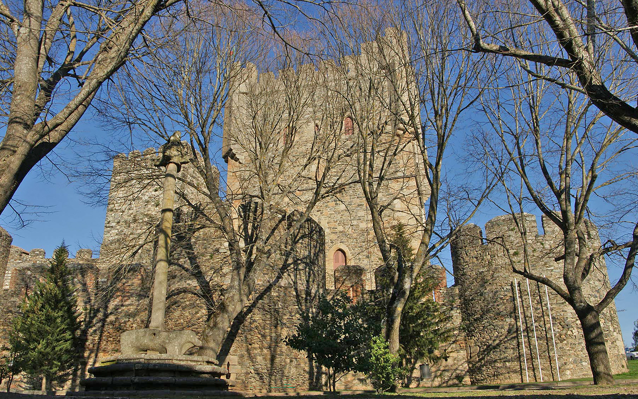 Außenansicht der Burg der Pousada Bragança mit Bäumen und Laub vor der Fassade