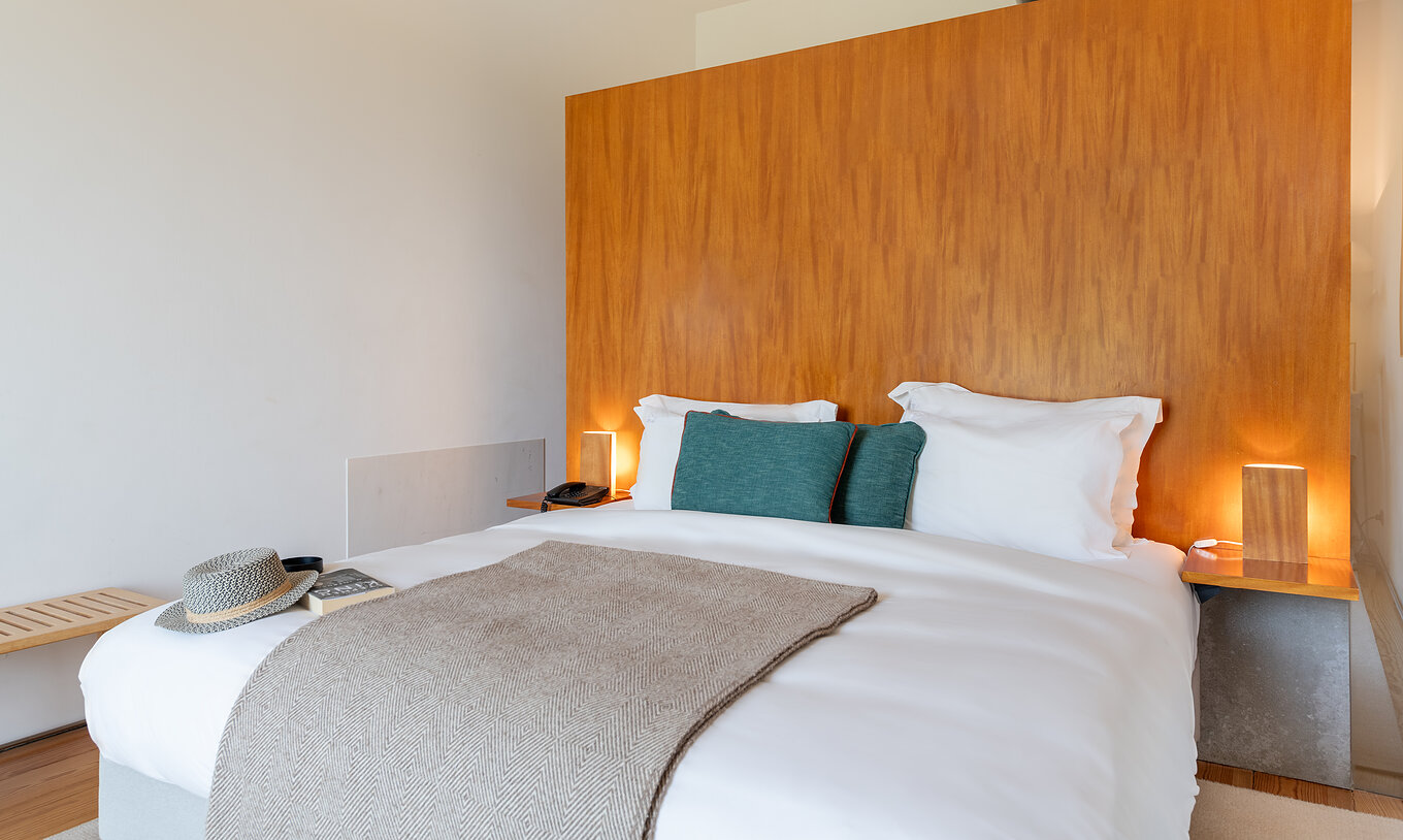 Das Klassische Zimmer der Pousada Mosteiro Amares hat ein Doppelbett mit einer hohen Holz Kopfteil und blauen Kissen