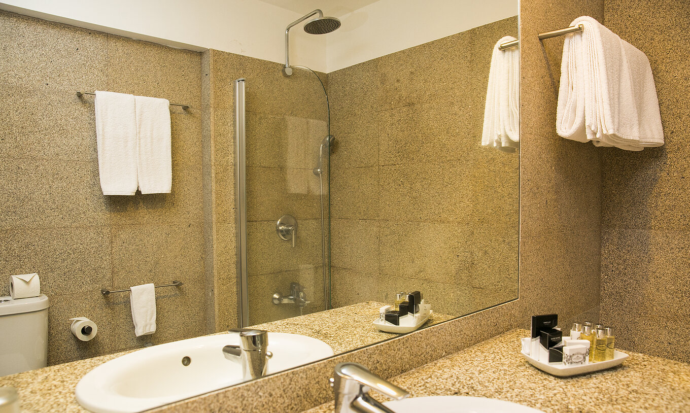 Der historische Superior Raum der Pousada Mosteiro Guimarães hat ein Badezimmer in Brauntönen mit Badewanne und Waschbecken