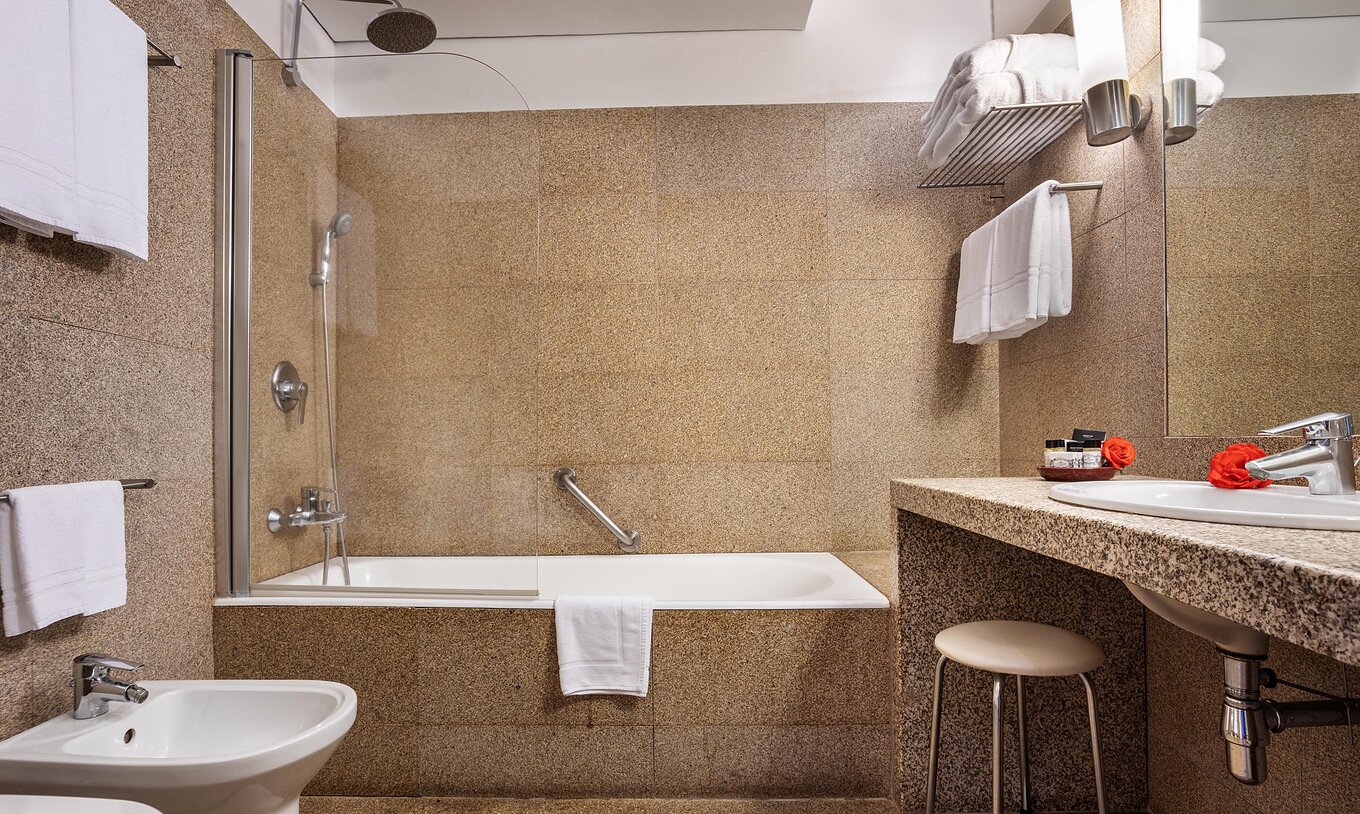 Der Superior Raum der Pousada Mosteiro Guimarães hat ein Badezimmer in Brauntönen mit Badewanne und Waschbecken