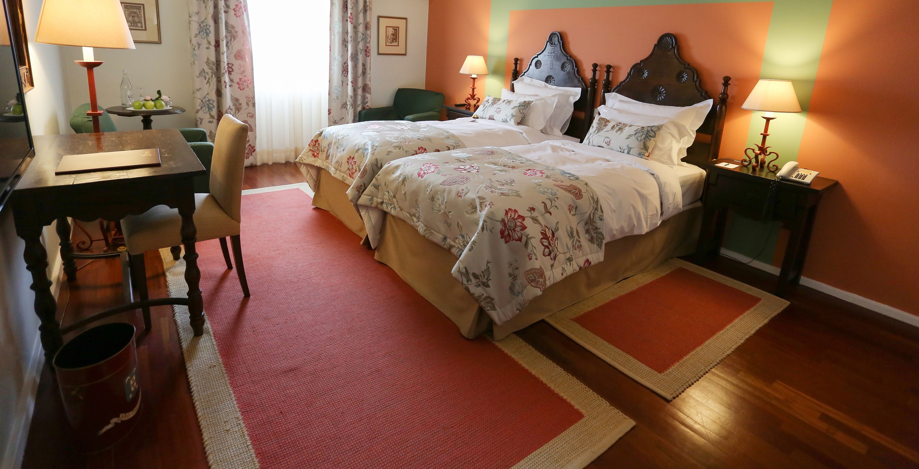 Die Large Family Suite der Pousada Valença hat zwei Einzelbetten mit Holz-Kopfteil, einen Schreibtisch und einen Sessel