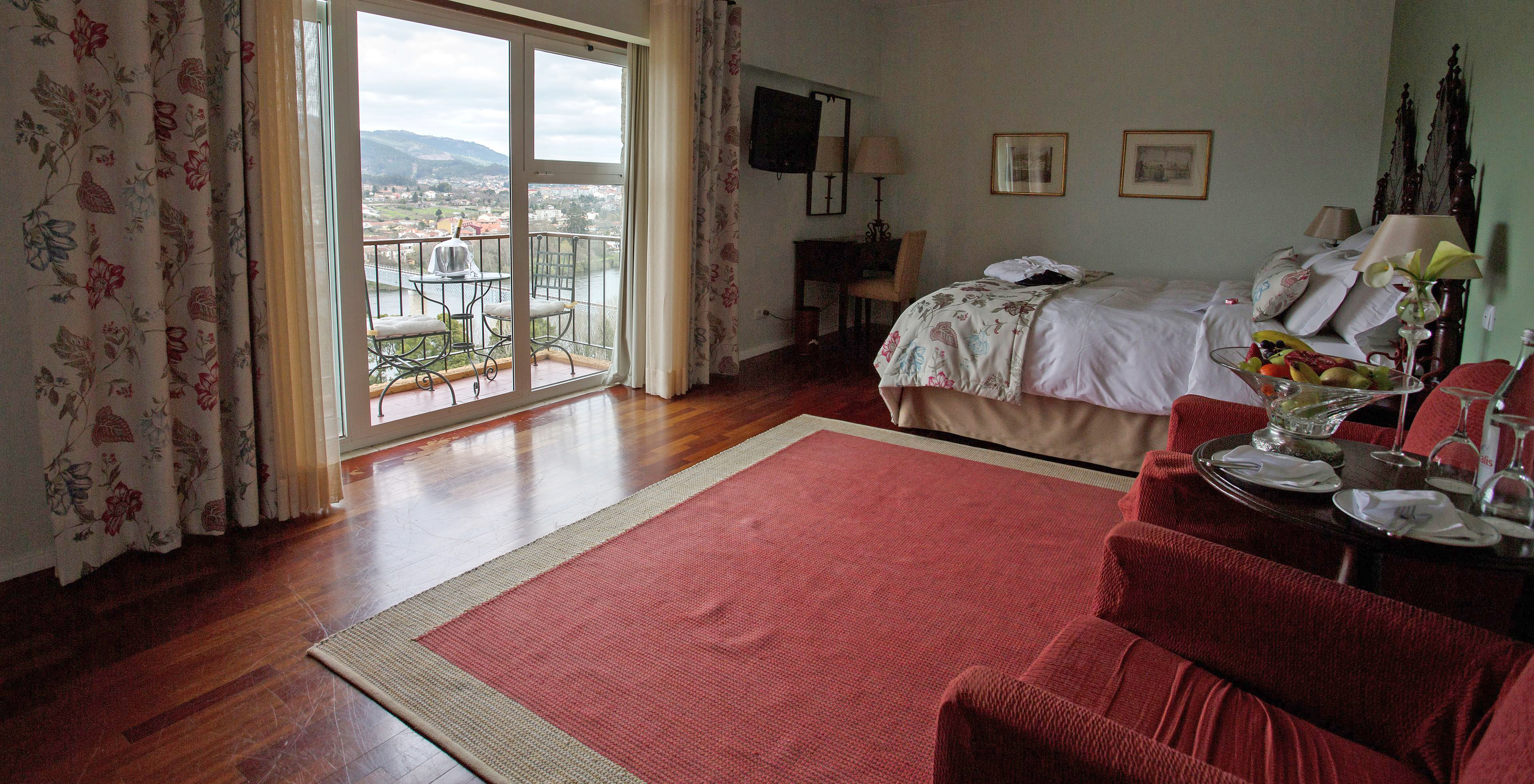 Das Superior Zimmer der Pousada Valença hat ein Doppelbett, zwei Sessel und einen Balkon