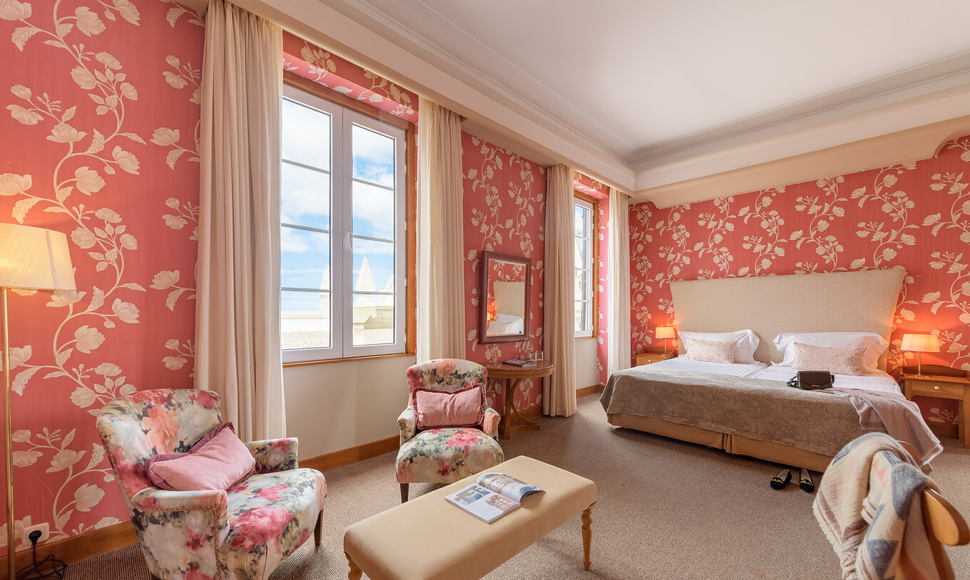 Das klassische Familienzimmer der Pousada Viana do Castelo hat zwei Fenster neben dem Bett und zwei Sessel zum Entspannen