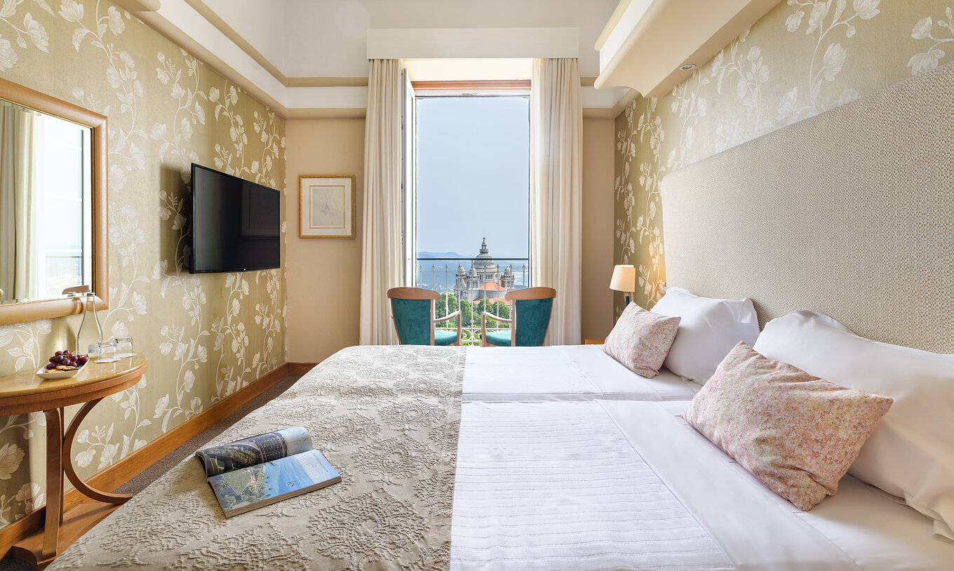 Das Superior Zimmer der Pousada Viana do Castelo hat zwei Stühle am Fenster mit Blick auf die Basilika von Santa Luzia