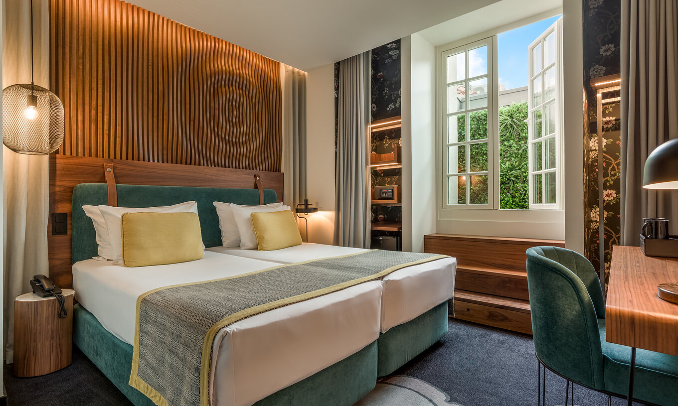 Das Cozy Room der Pousada Porto - Rua das Flores hat ein grünes Kopfteil und eine Wand mit gewellten Holzlatten