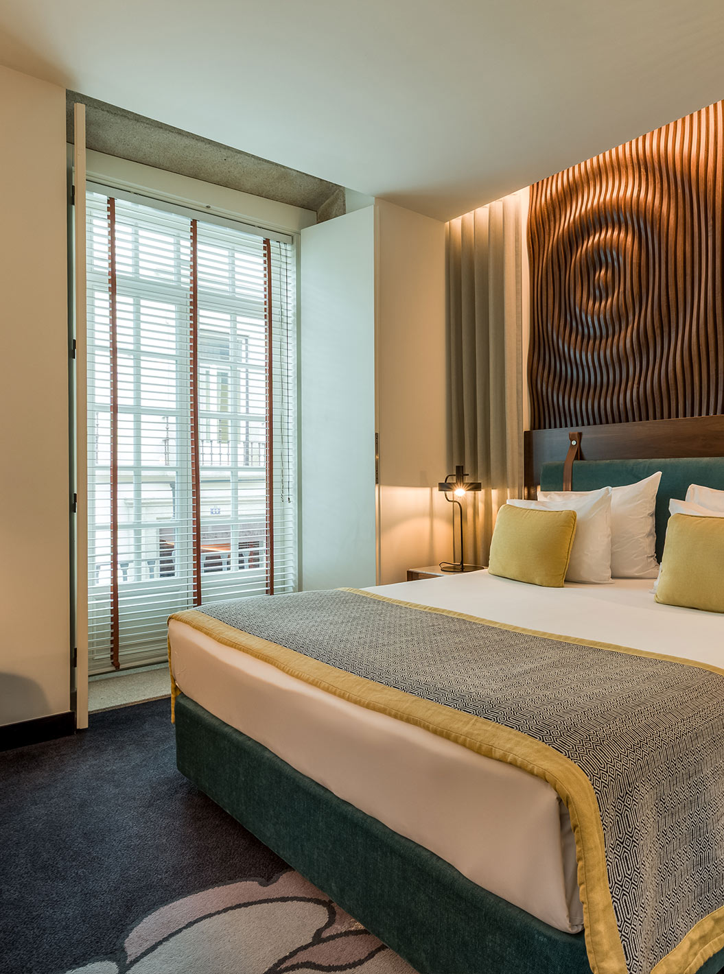 Das Deluxe der Pousada Porto - Rua das Flores hat ein großes Doppelbett mit grünem Kopfteil und einer Holzwand