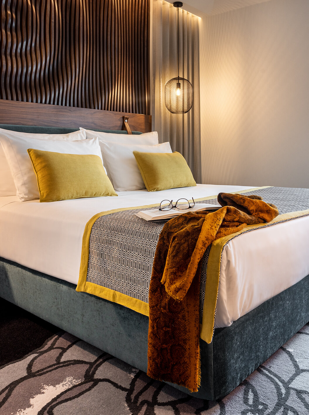 Die Junior Suite der Pousada Porto - Rua das Flores hat ein türkisfarbenes Doppelbett, weiße Bettwäsche und ein Holz-Kopfteil