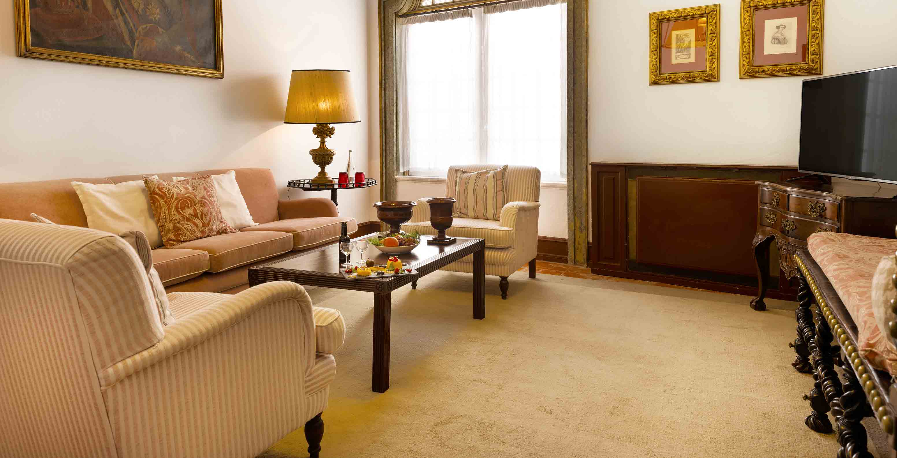 The Special Suite has a living room with sofa, armchairs, TV and a large window at Pousada Castelo Estremoz