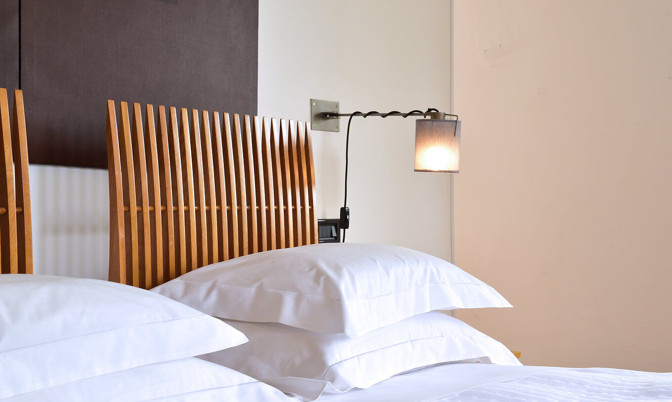 The Classic Room of The Pousada Convento Arraiolos has two single beds with white sheets and a wooden headboard