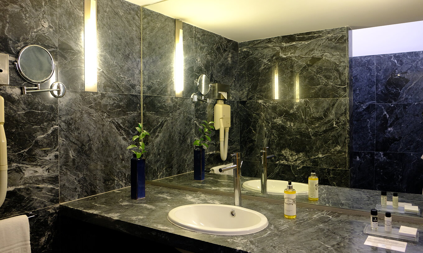 The Large Family of The Pousada Convento Arraiolos has a dark marble bathroom with a large counter and a sink