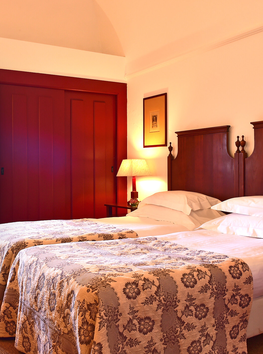 The Superior Room of The Pousada Convento Beja has two joined beds with a gray bedspread, a window, and wardrobes