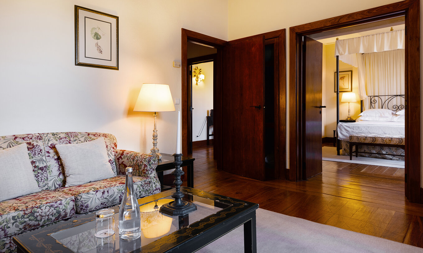 The Special Suite of The Pousada Convento Vila Viçosa has a living room with a sofa, a coffee table, and a bottle of water