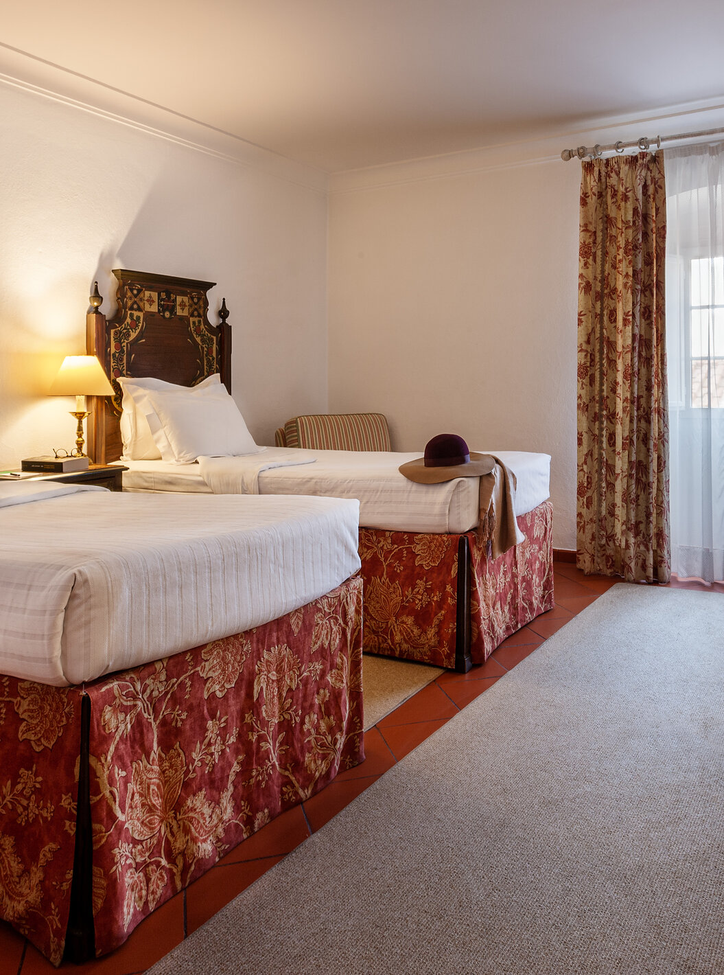 The Family Room with Balcony of The Pousada Marvão features two separate beds with a floral pattern and a counter