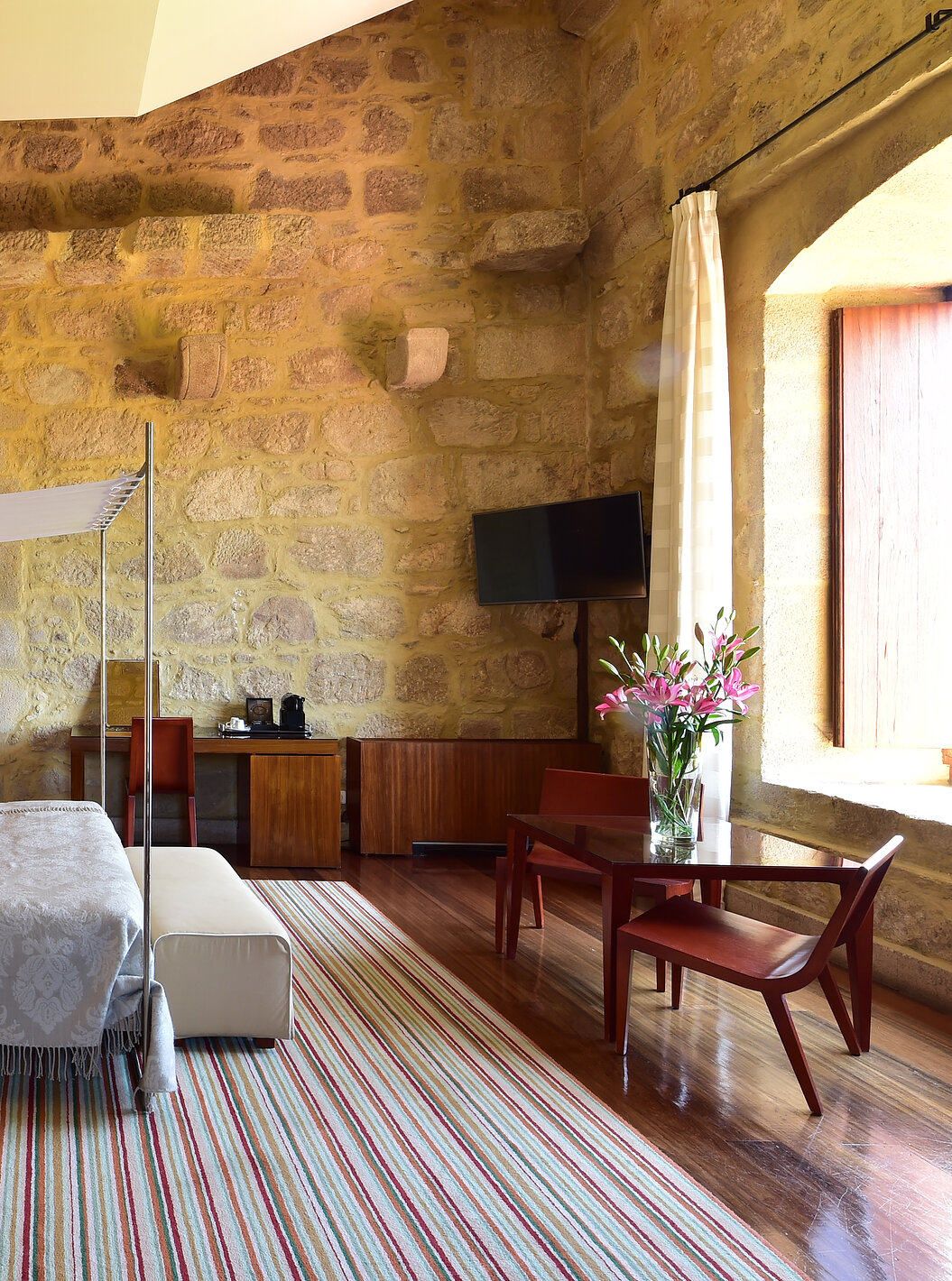 The Master Suite of The Pousada Mosteiro Crato is spacious with a four-poster double bed and also has a desk and a television