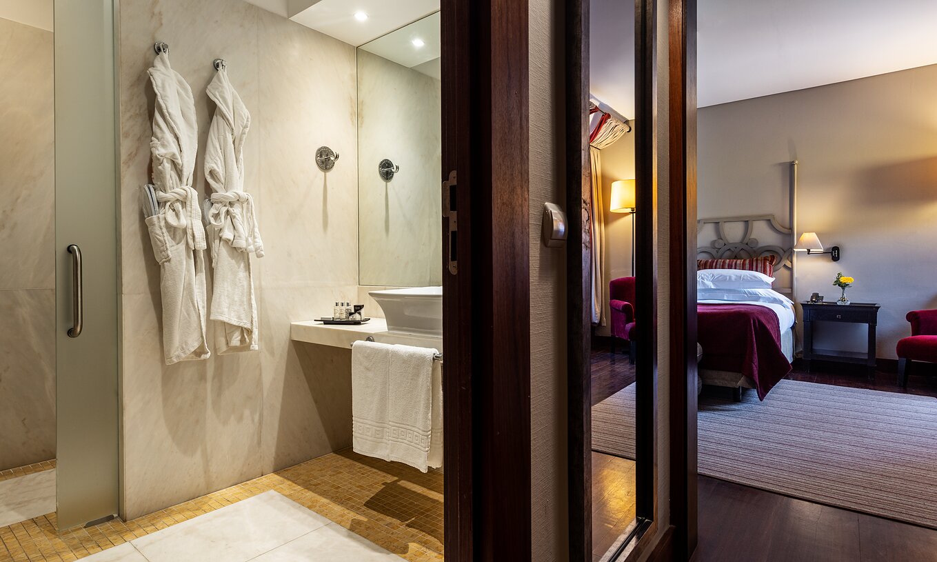 The Classic Room of The Pousada Convento Tavira has a corridor at the entrance with a door to the bathroom and a mirror