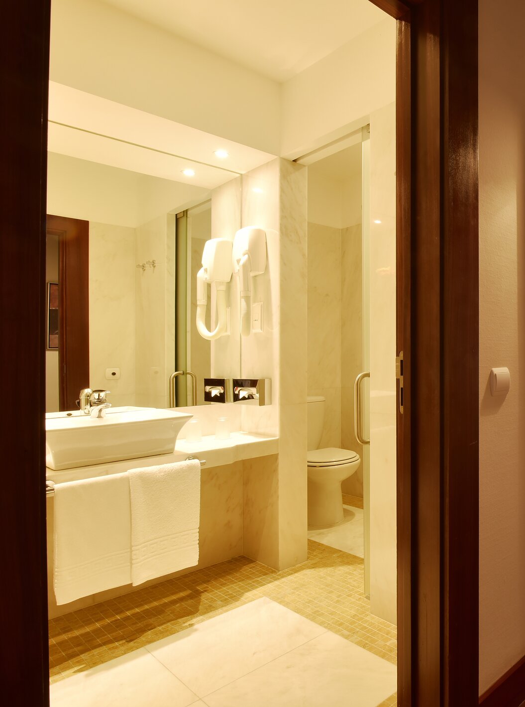 The Superior Room of The Pousada Convento Tavira has a corridor at the entrance with a door to the bathroom with sink 