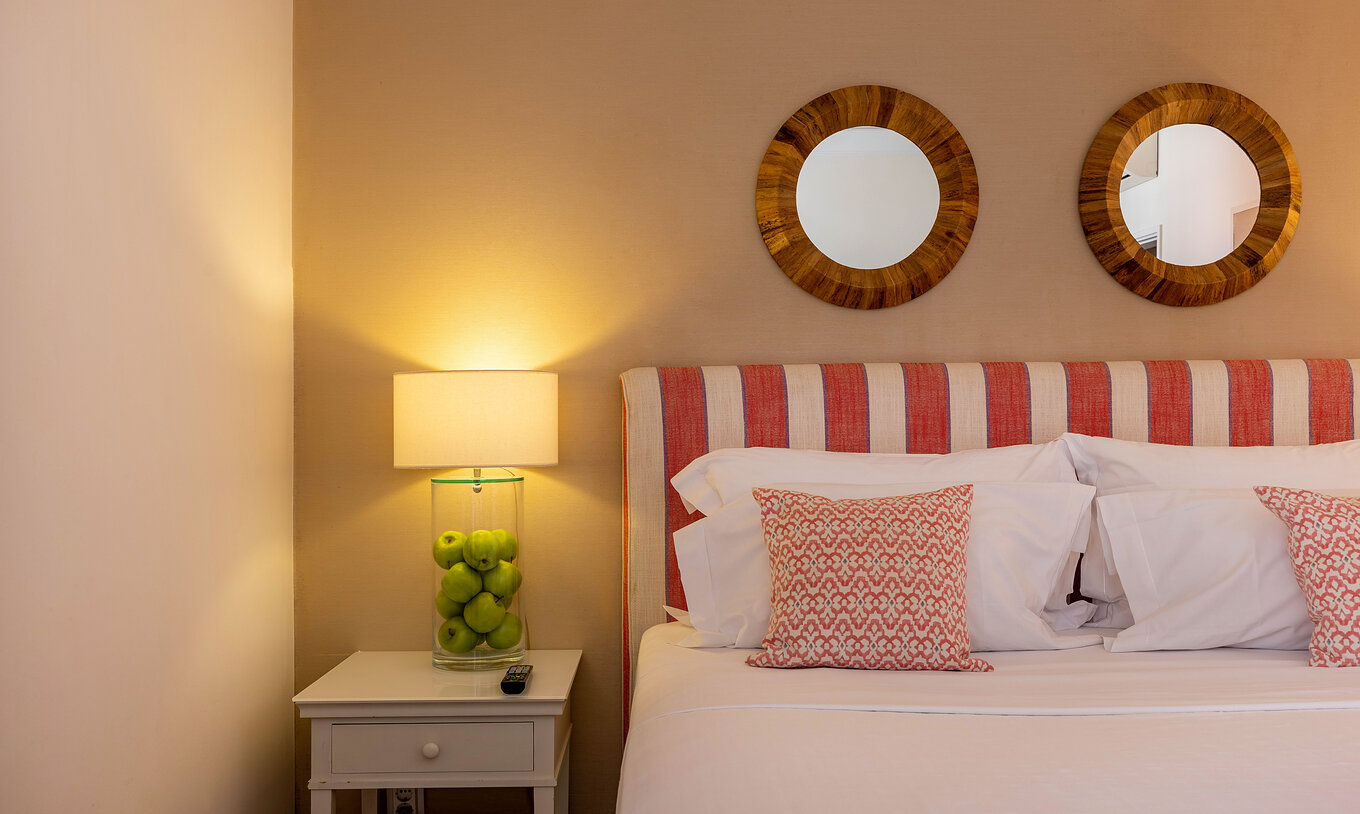 The Classic Room of Pousada Sagres has two beds with striped headboards and two round mirrors