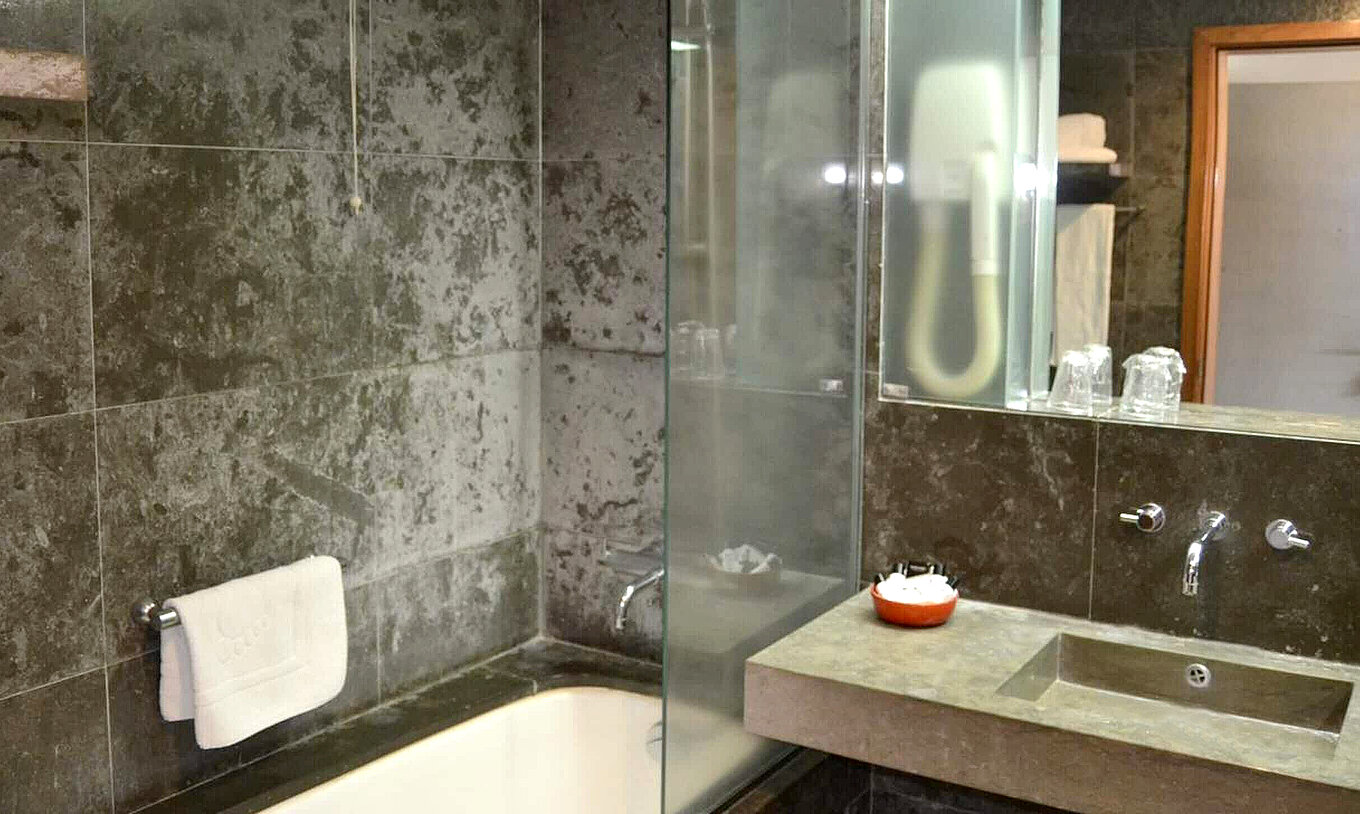 The Classic Room of The Pousada Forte Angra do Heroísmo has a tiled bathroom with bathtub, sink, and shower