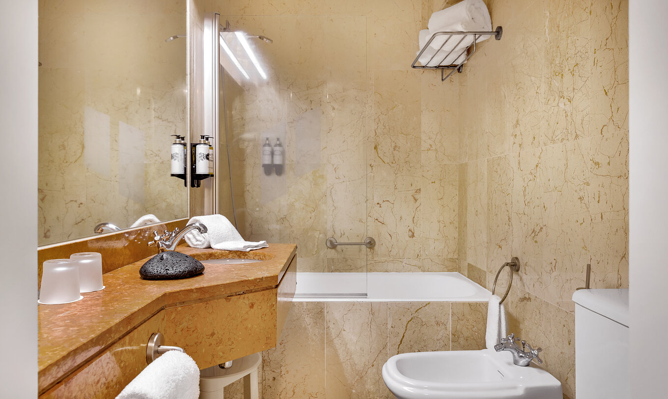 The Classic Room of The Pousada Forte Horta has a bathroom with sink, bathtub with shower, and towel