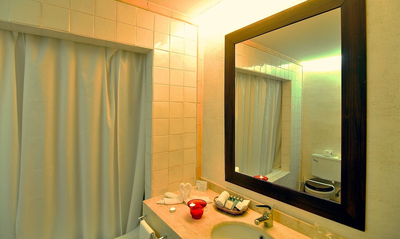 The Deluxe Room of The Pousada Convento de Belmonte has a bathroom with a bathtub, sink, and mirror