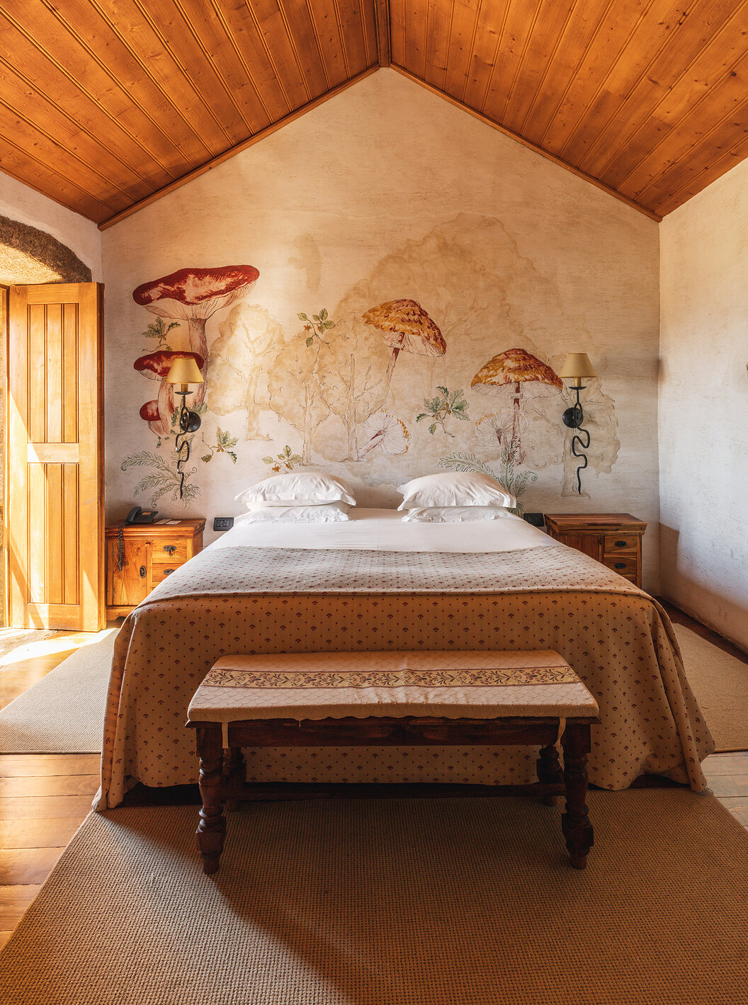 The Superior Suite with Balcony of The Pousada Convento de Belmonte has a double bed and mushrooms painted on the wall
