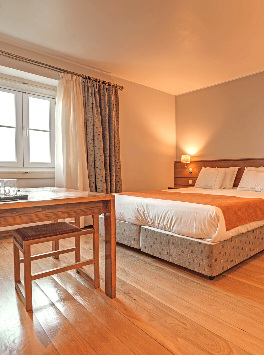 The Superior Room of The Pousada Ourém features a double bed with two bedside tables and a side table