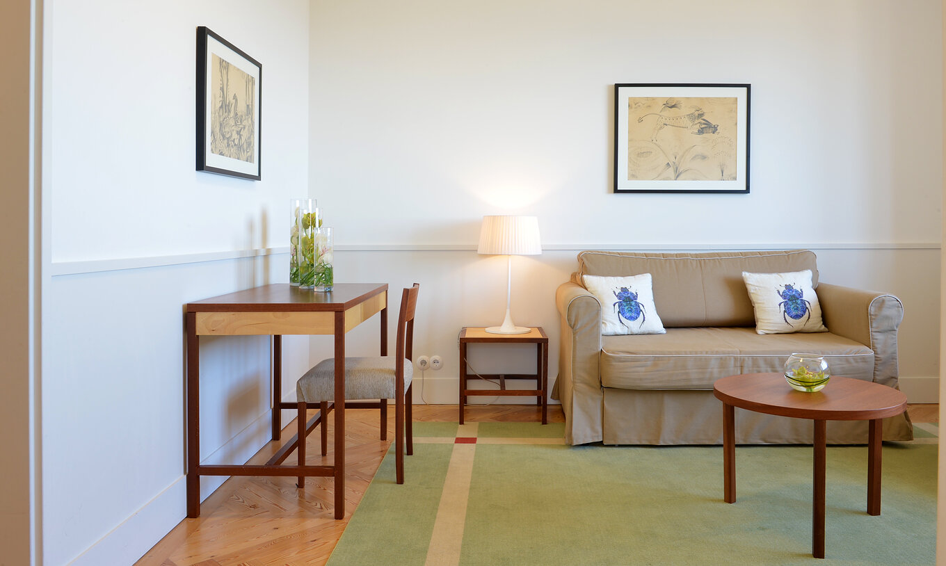 The Large Family & Suite of The Pousada Serra da Estrela has a living room with a sofa, a painting, and a desk