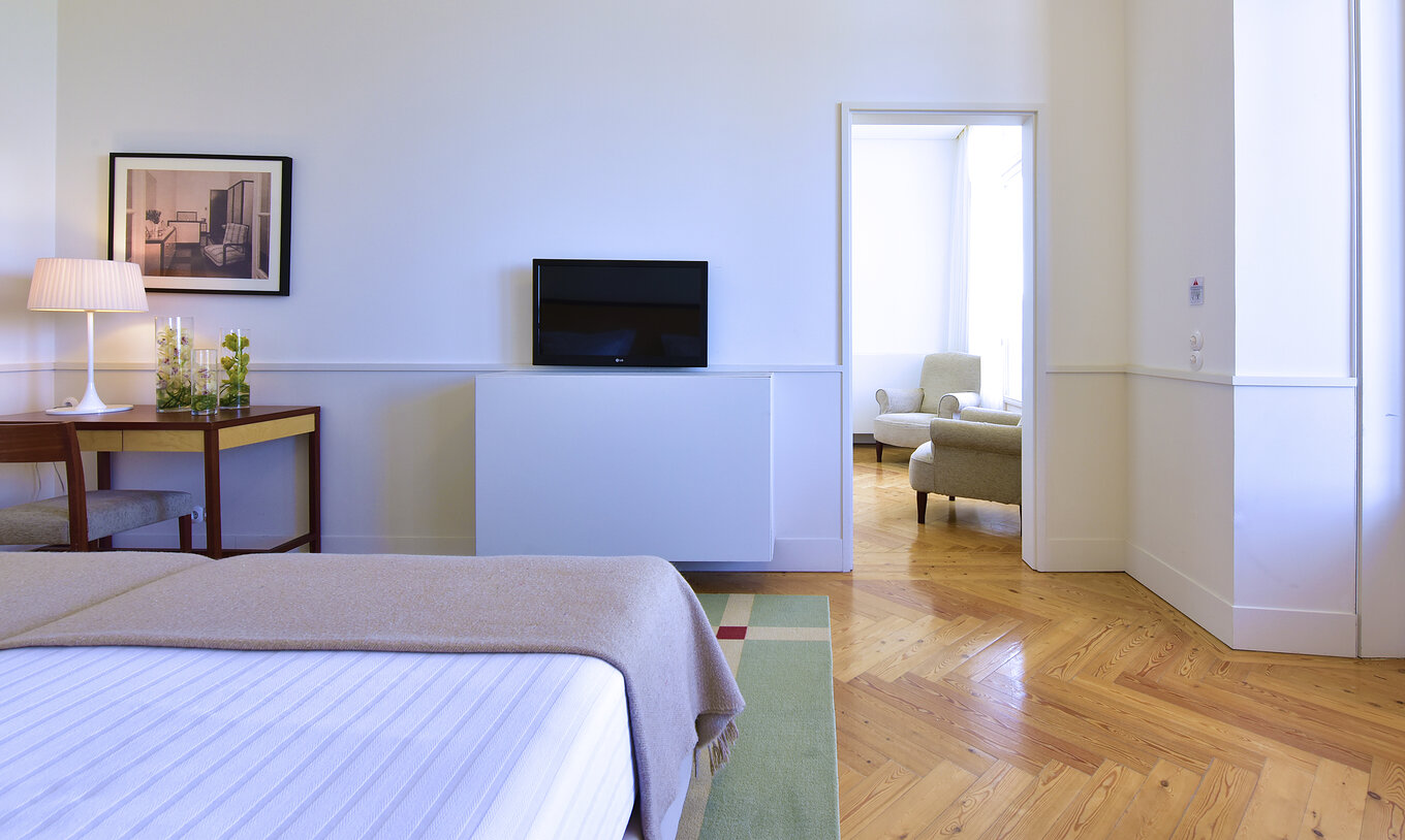 The Superior Family of The Pousada Serra da Estrela has a bedroom with two beds, a television in front, and a desk