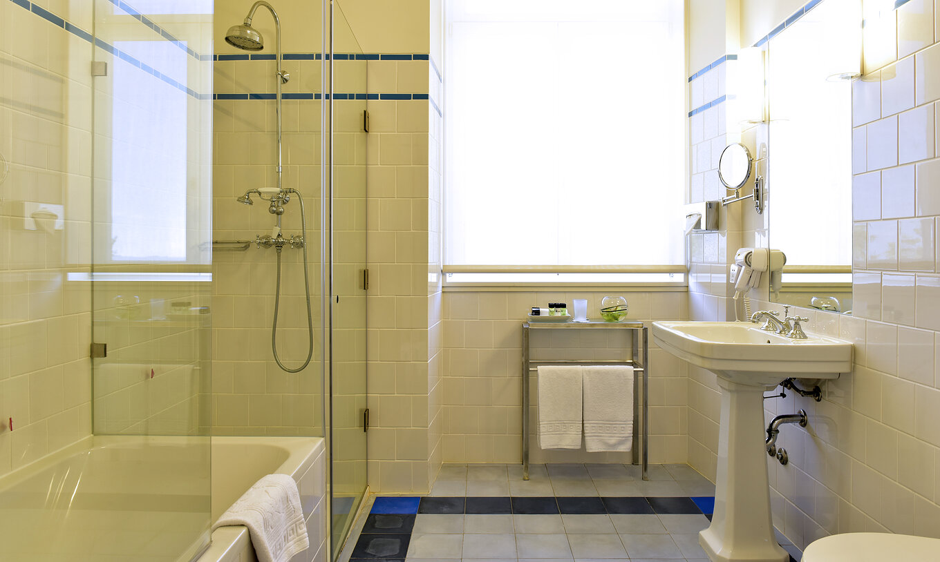 The Superior Room of The Serra da Estrela Inn has a bathroom with shower, bathtub, and sink with mirror